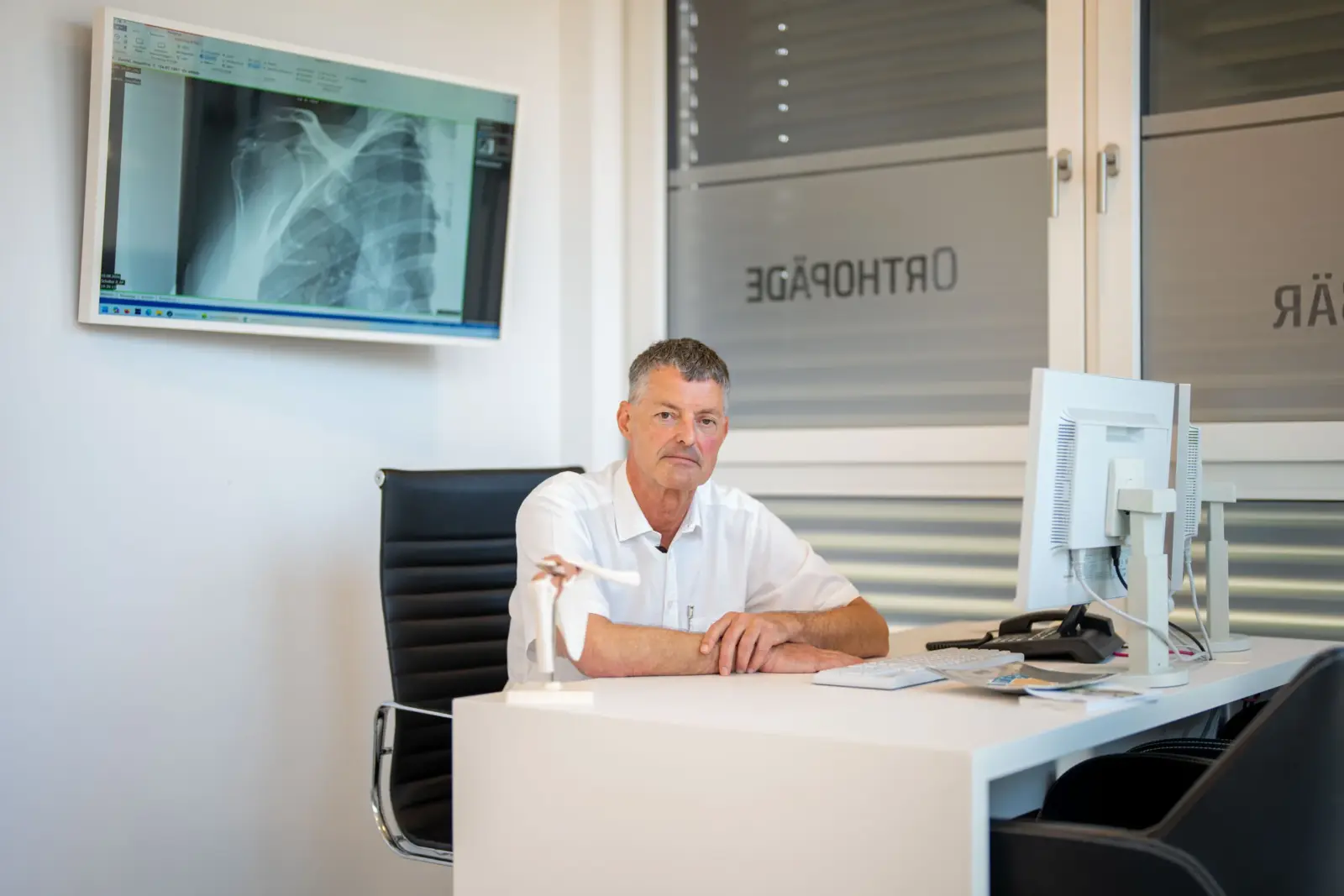 Dr. Knut Bär am Schreibtisch mit Röntgenbild